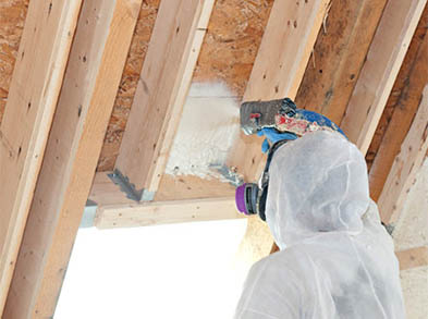 spray foam installer spraying attic