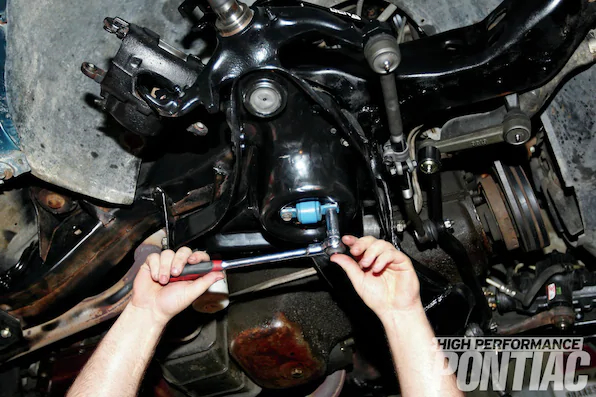 21. The front shocks were mounted by sliding the shock body up through the hole in the lower control arm and into an access hole in the upper control arm. The top of each shock is retained with a polyurethane bushing, washer, and nut. The bottom was bolted on through the shock body with two bolts and torqued to spec.